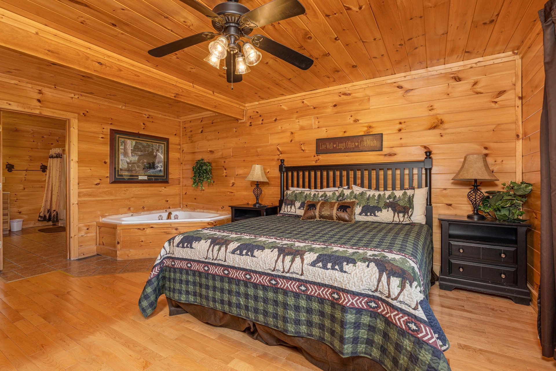 Bedroom with a king bed, night stands, lamps, and jacuzzi at Bears Dont Bluff, a 3 bedroom cabin rental located in Pigeon Forge