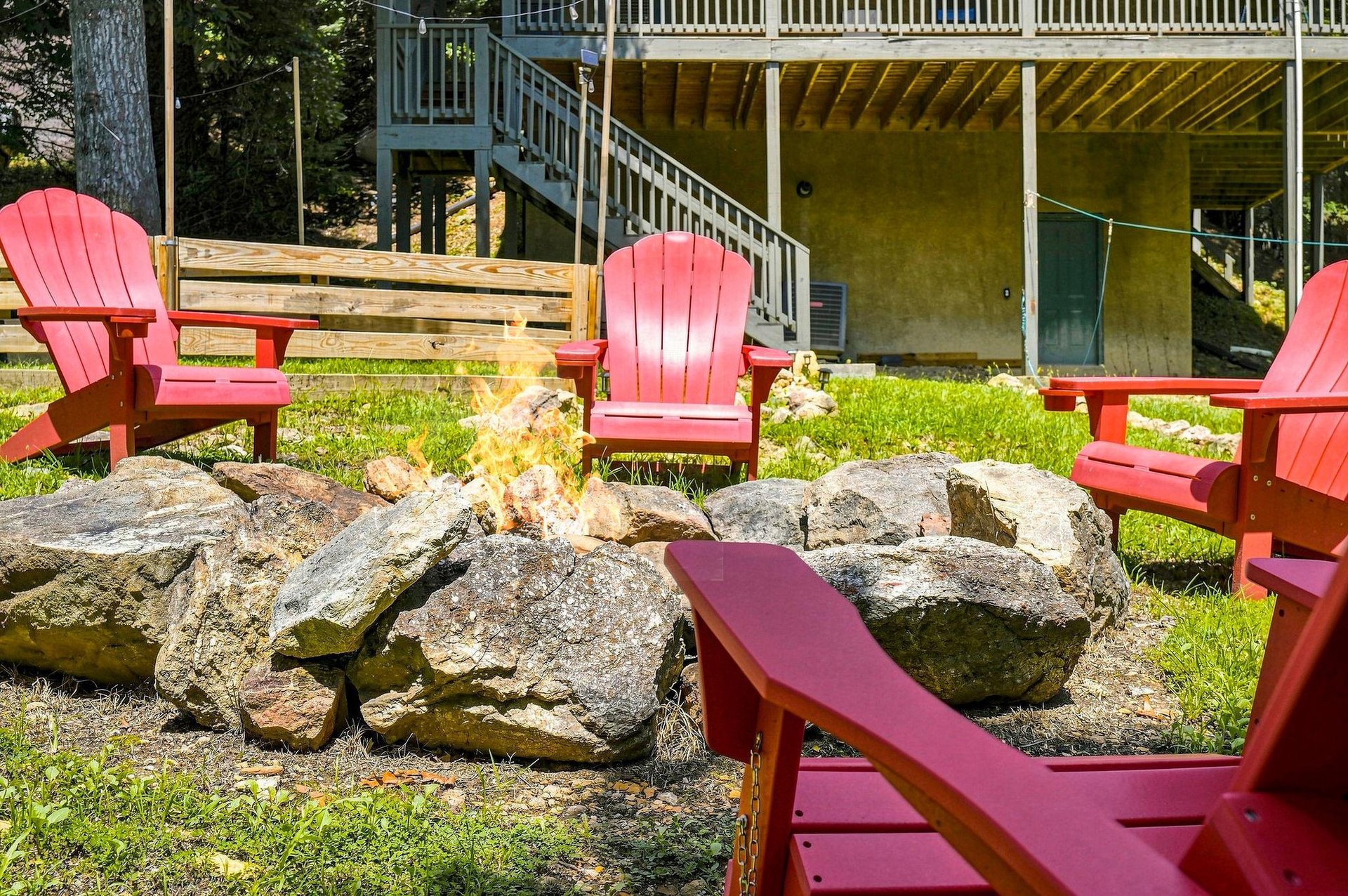 Picture yourself gathered around this rustic fire pit in vibrant Adirondack chairs, sharing stories under open sky. A perfect spot for your evening winddown.