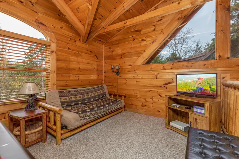 Futon and TV in the loft at Livin Simple, a 2 bedroom cabin rental located in Pigeon Forge