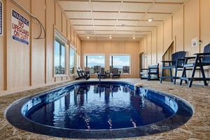 Your private indoor pool with chairs and windows framing scenic views—perfect for a relaxing swim any time of day.