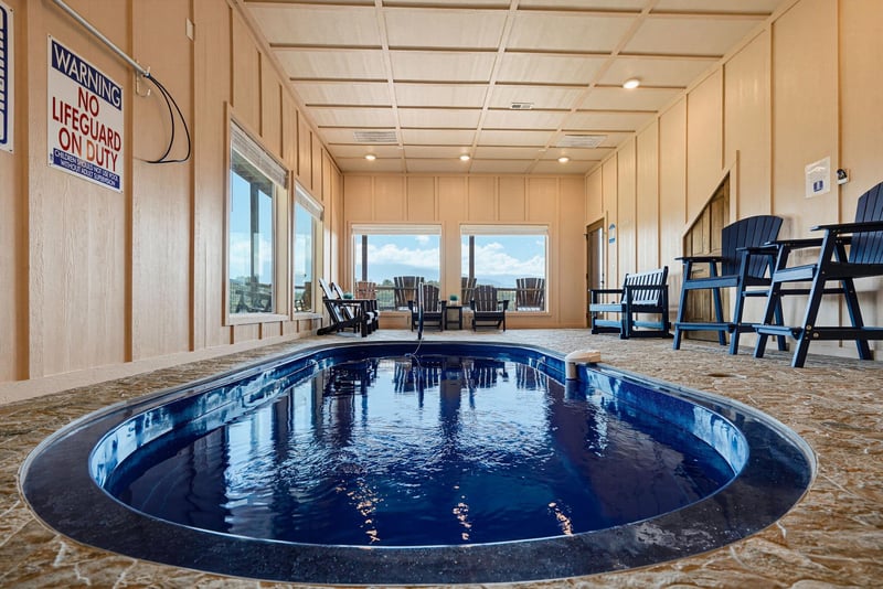 Your private indoor pool with chairs and windows framing scenic views—perfect for a relaxing swim any time of day.
