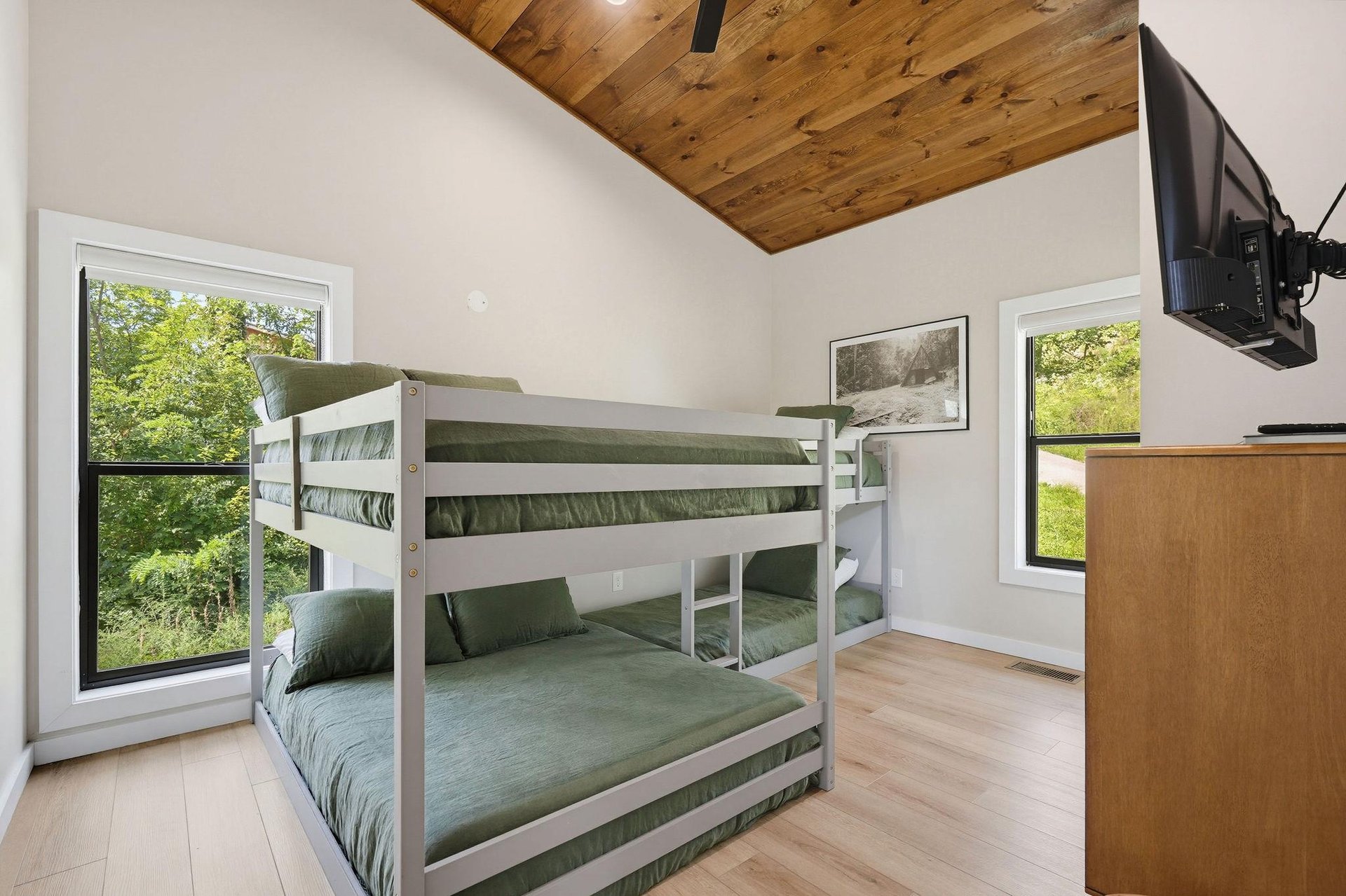 Your family can unwind in this cozy bunk room, where warm wood ceilings and leafy views create a peaceful retreat for restful nights and lazy mornings.