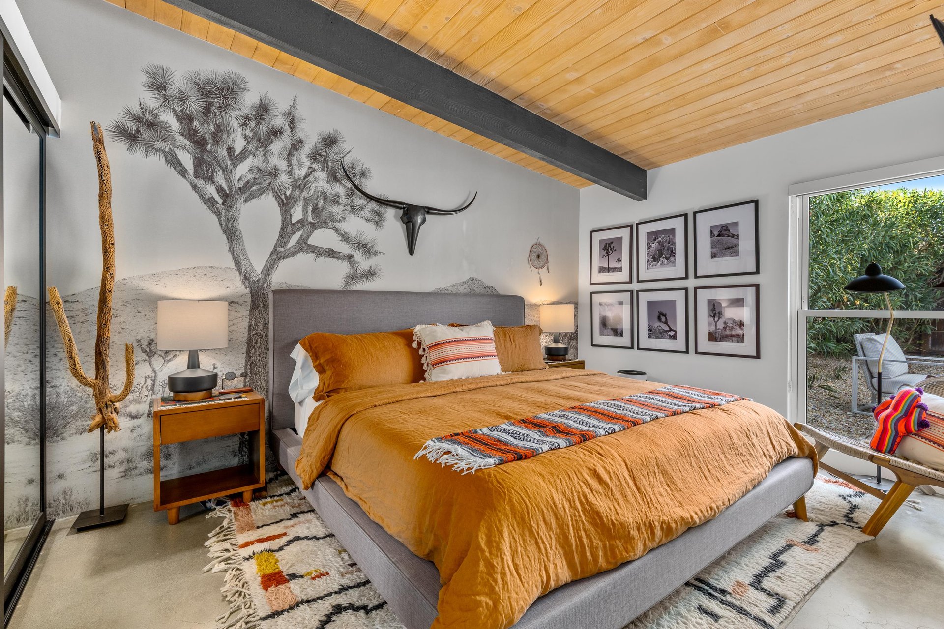 Drift off in this desertinspired bedroom where warm orange bedding meets artistic touches and exposed beams create your perfect retreat.