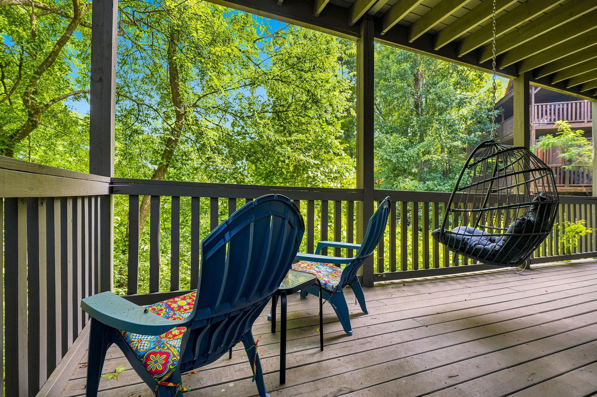 Settle into your private balcony with lush forest views framing every moment. Vibrant cushions and a cozy hanging chair invite you to unwind outdoors in serene natural beauty.