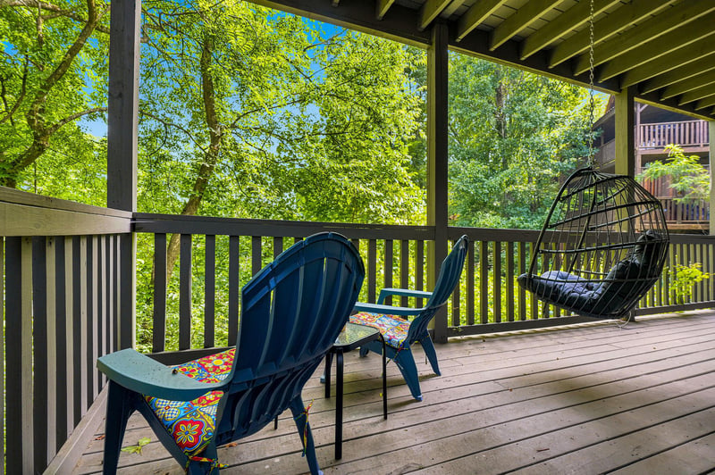 Settle into your private balcony with lush forest views framing every moment. Vibrant cushions and a cozy hanging chair invite you to unwind outdoors in serene natural beauty.