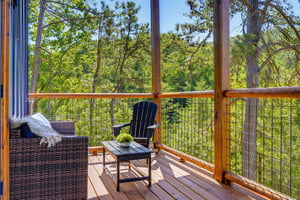 Picture yourself relaxing on this private deck surrounded by towering pines. Sink into the cozy outdoor seating with a warm throw, breathe in the fresh forest air, and let the peaceful treetop views m