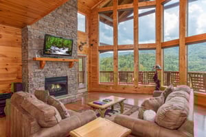 Vaulted ceilings with floortoceiling windows, fireplace, and TV at Four Seasons Lodge, a 3bedroom cabin rental located in Pigeon Forge
