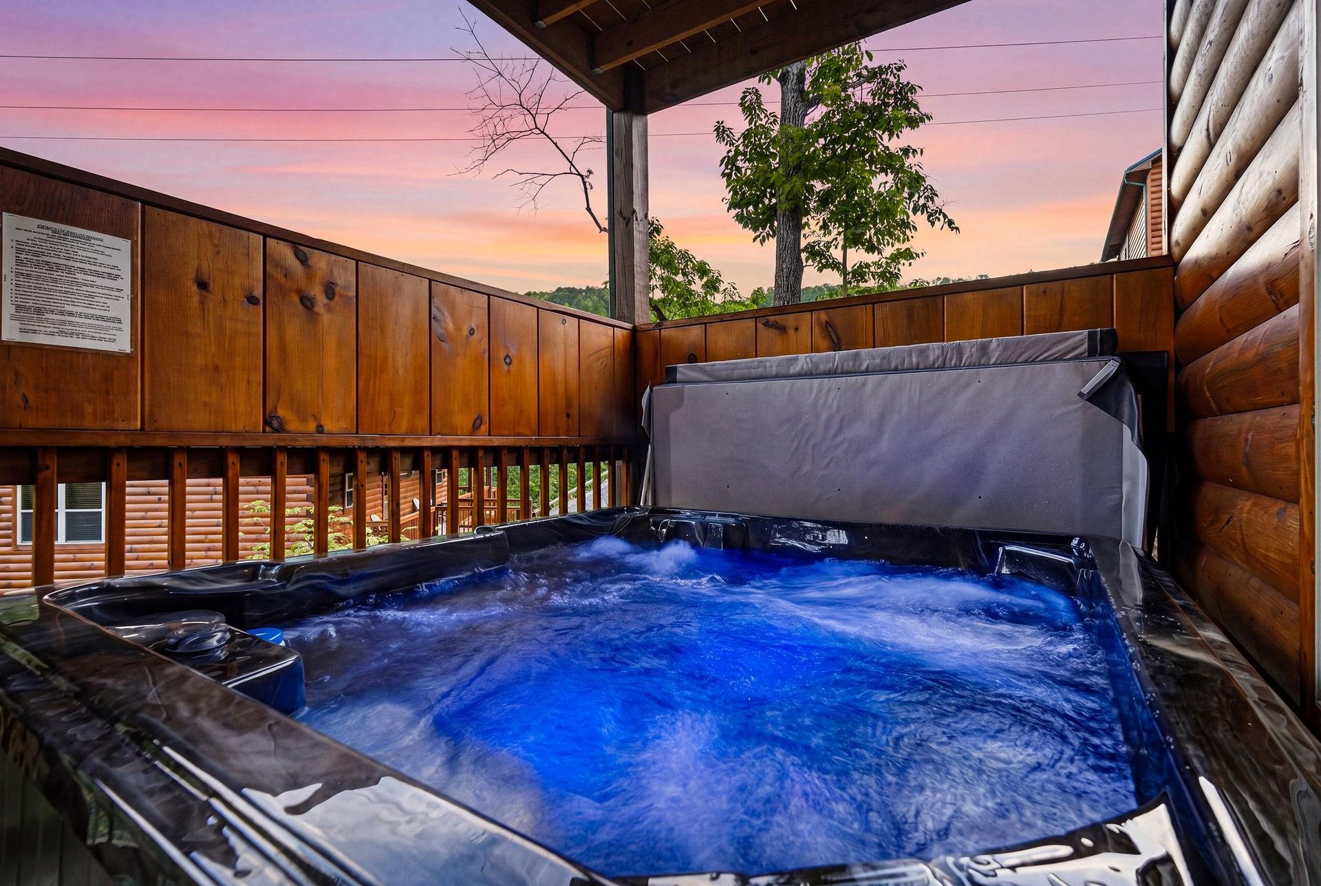 Soak in the hot tub on your private deck as the sun sets behind the trees, painting the sky in stunning shades of pink and purple over the peaceful mountain landscape.
