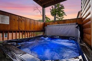 Soak in the hot tub on your private deck as the sun sets behind the trees, painting the sky in stunning shades of pink and purple over the peaceful mountain landscape.