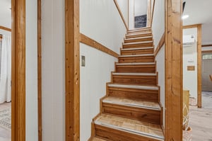 Warm wooden stairs invite you upstairs in this beautifully crafted home with natural timber details throughout.