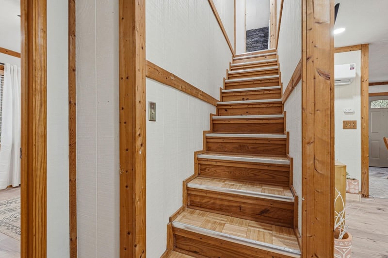 Warm wooden stairs invite you upstairs in this beautifully crafted home with natural timber details throughout.