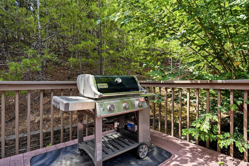 Fire up the grill on your private deck, surrounded by lush forest views and dappled sunlight filtering through the trees—your perfect spot for outdoor cooking.