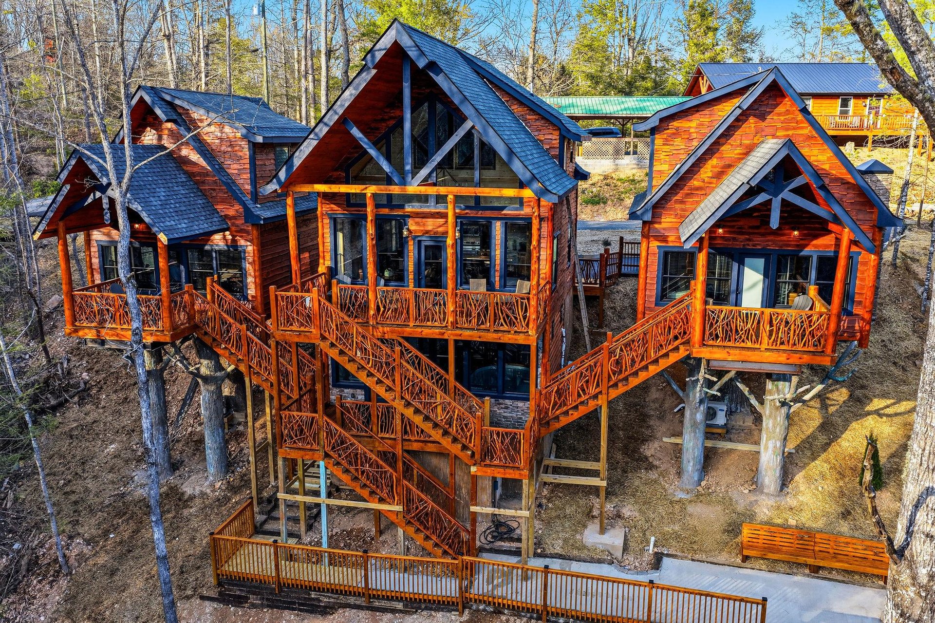 Elevated treehousestyle cabin with wraparound decks nestled among mature trees, offering a unique forest retreat experience.