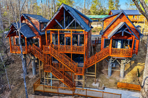 Elevated treehousestyle cabin with wraparound decks nestled among mature trees, offering a unique forest retreat experience.