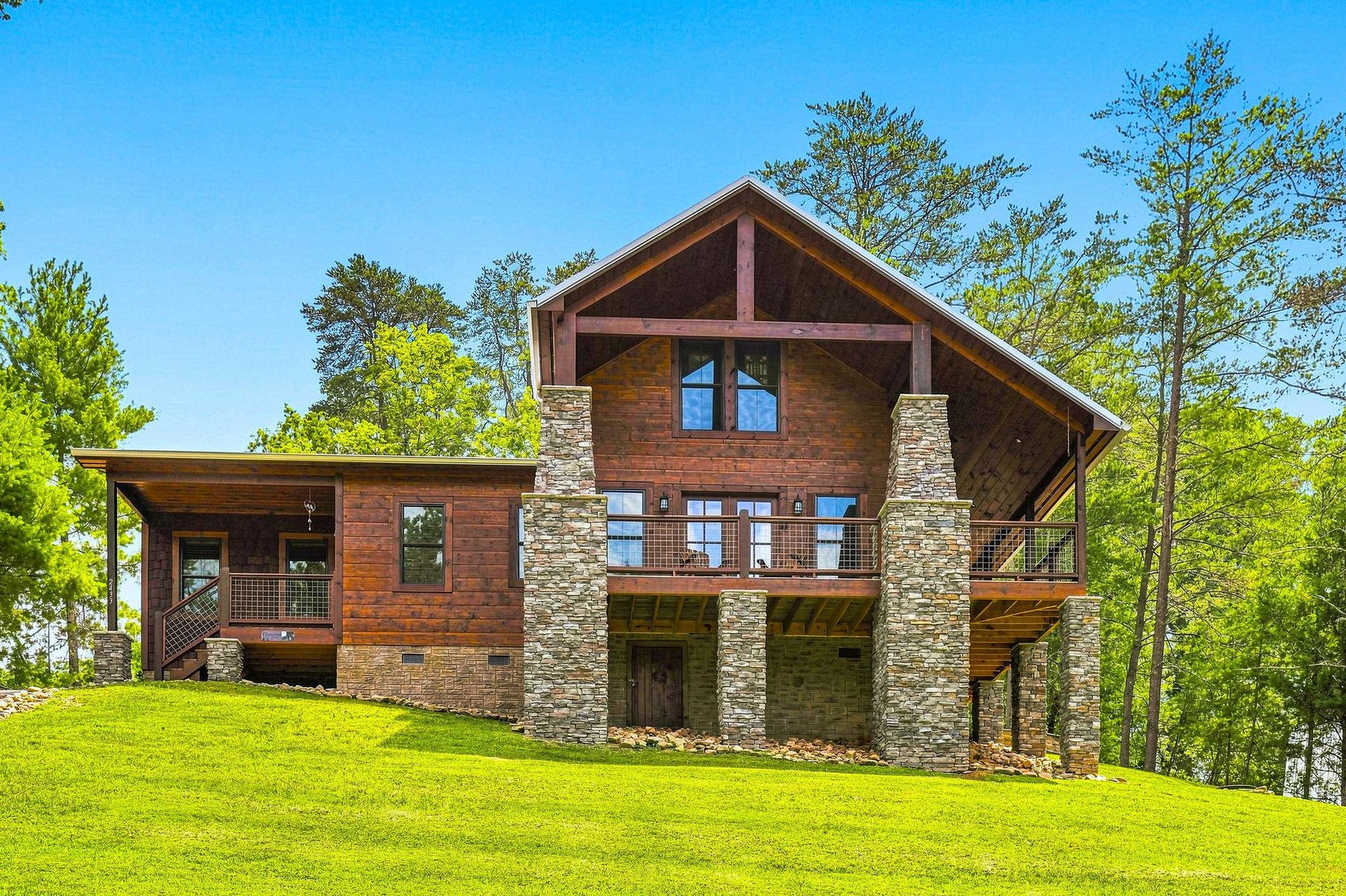 This stunning lakeside lodge showcases rustic wood and stone architecture set among towering pines, offering a peaceful retreat with modern mountain charm and expansive outdoor spaces.