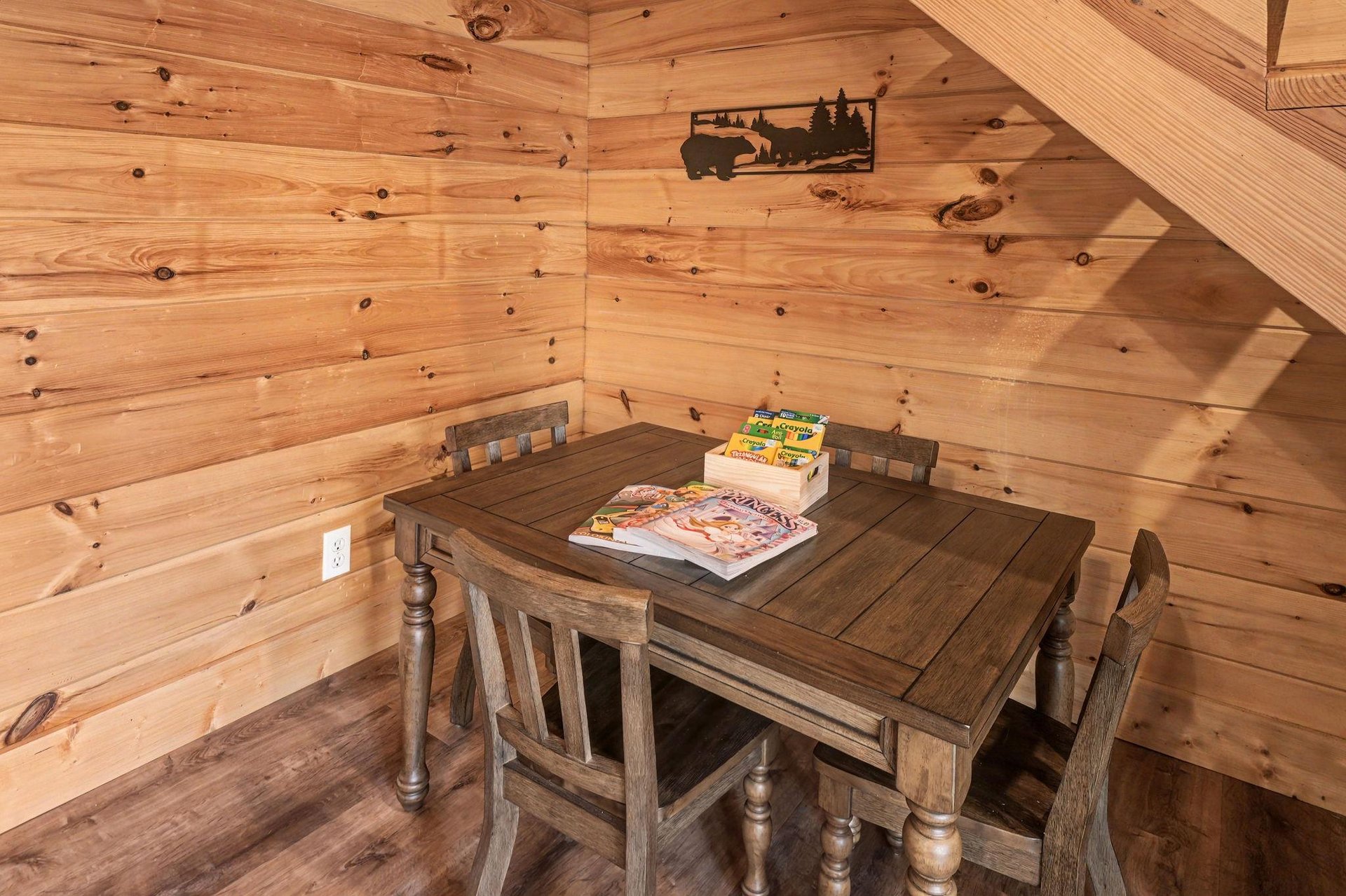 Your cozy reading nook awaits with rustic wooden table perfect for morning coffee and games under slanted ceilings.