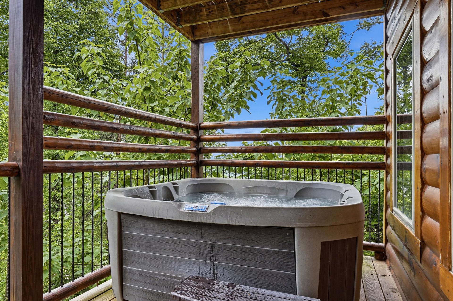 Soak beneath a canopy of vibrant greenery and blue sky in your private hot tub, where natures beauty wraps around you for pure outdoor relaxation.
