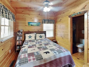 Snuggle into your cozy cabin bedroom, where warm pine walls and rustic charm invite peaceful mountain dreams. Your private space features charming woodland details and thoughtful touches for comfort.