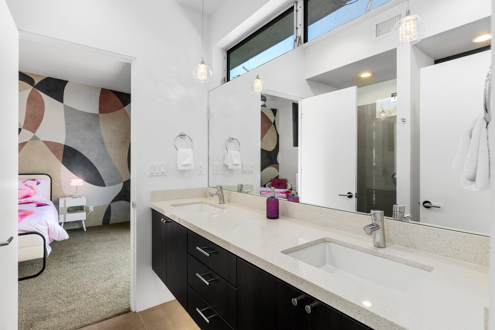 Jackandjill bathroom shared between guest bedroom 1 and 2 with dual vanity sinks and stand alone shower.