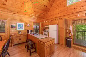 Kitchen with white appliances and breakfast bar at Grand View, a 3 bedroom cabin rental located in Sevierville