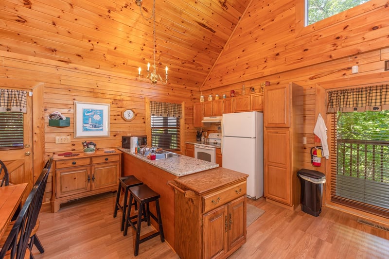 Kitchen with white appliances and breakfast bar at Grand View, a 3 bedroom cabin rental located in Sevierville