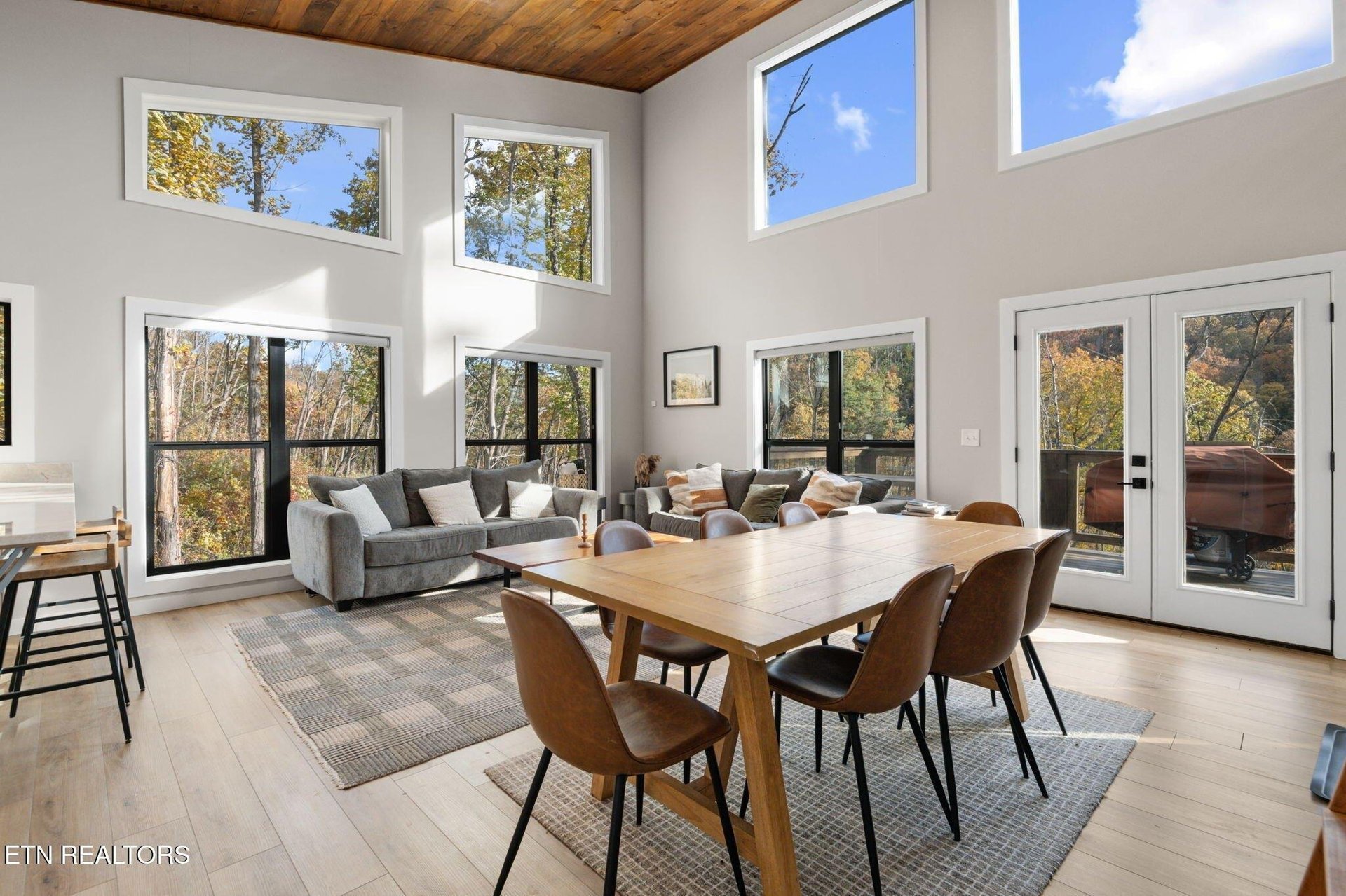 A stunning openplan living and dining space flooded with natural light from floortoceiling windows. Warm wood tones and autumn views create your perfect retreat for gathering with loved ones.