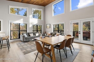 A stunning openplan living and dining space flooded with natural light from floortoceiling windows. Warm wood tones and autumn views create your perfect retreat for gathering with loved ones.