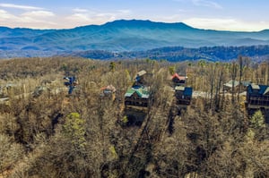 Mountain cabin community nestled among forested hills with stunning Blue Ridge peaks creating a scenic backdrop.