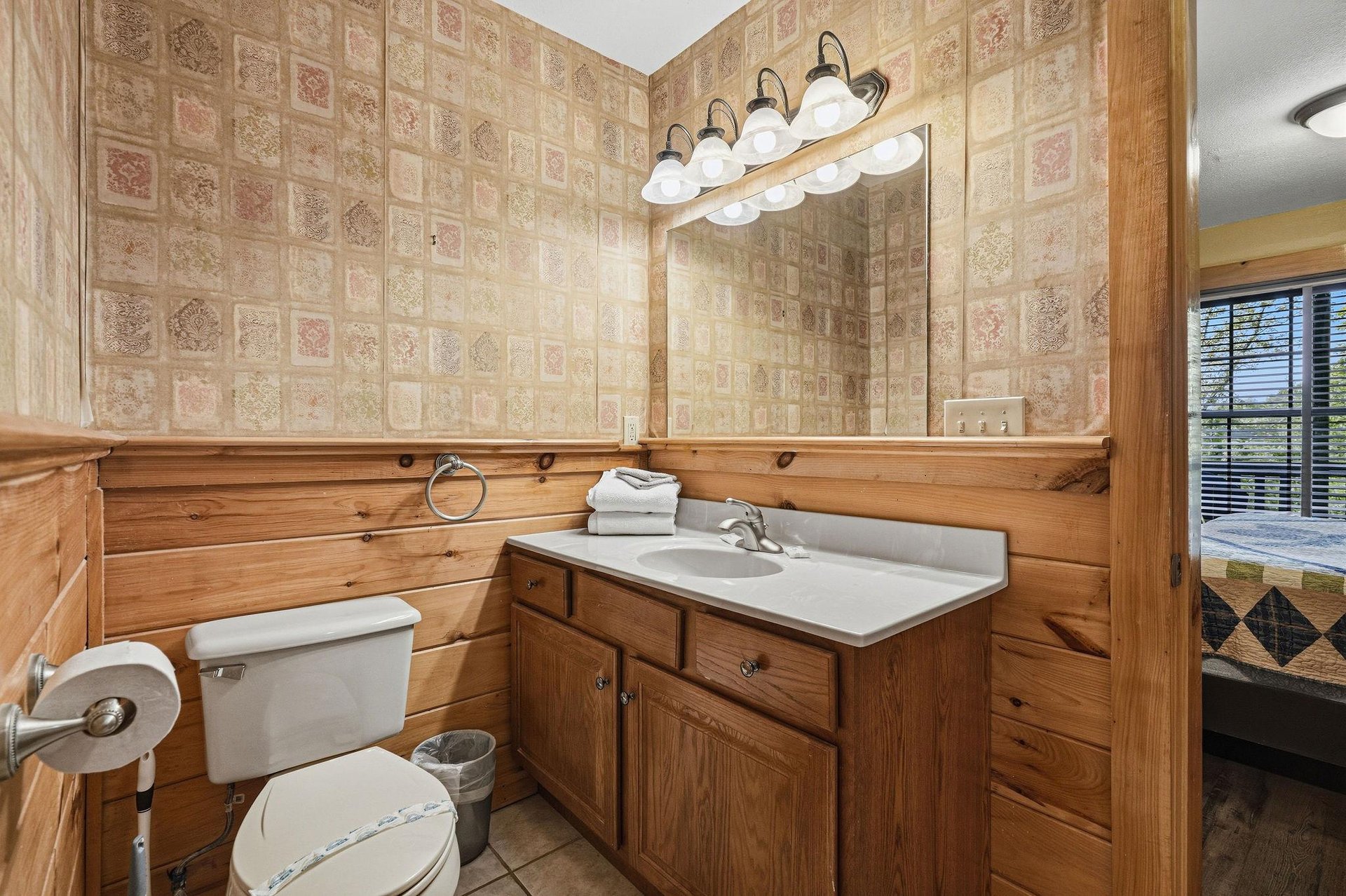 Step into your charming bathroom with warm wood paneling and thoughtful touches that make you feel right at home.