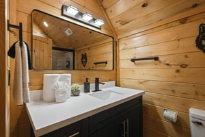 Warm wood walls and modern fixtures create your perfect bathroom retreat, complete with fluffy towels and thoughtful amenities.
