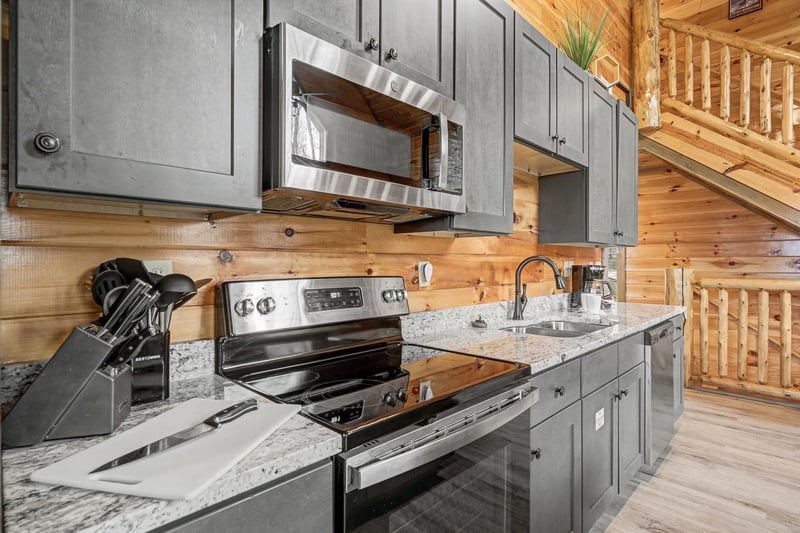 Your mountain retreats modern kitchen features granite counters, stainless appliances, and rustic wood walls—perfect for preparing memorable meals.