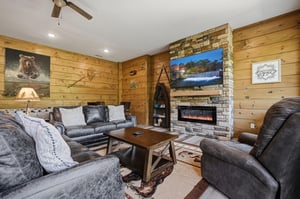 Cozy up in your rustic living room where leather seating surrounds a warm fireplace, perfect for relaxing evenings.