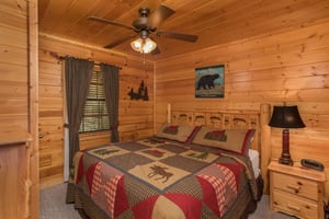 Bedroom with a bed, night stand, and lamp at Kick Back  Relax A 4 bedroom cabin rental located in Pigeon Forge
