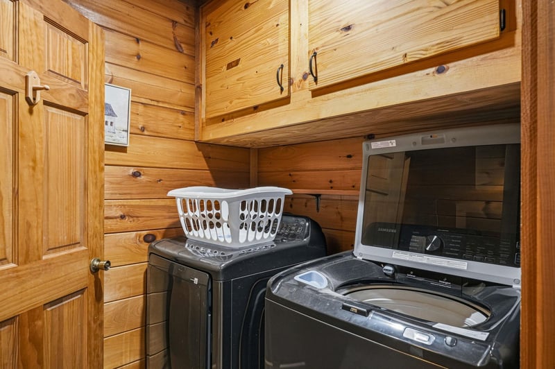Keep your wardrobe fresh with dedicated laundry facilities featuring a washer and dryer in this cozy cabinstyle space.