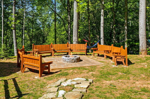 Gather around your private fire pit surrounded by handcrafted wooden benches, perfect for evening stories under towering forest canopy.
