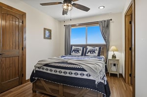 Unwind in your cozy bedroom with rustic charm and a plush bed dressed in mountaininspired linens. Soft natural light fills the space, inviting restful nights.