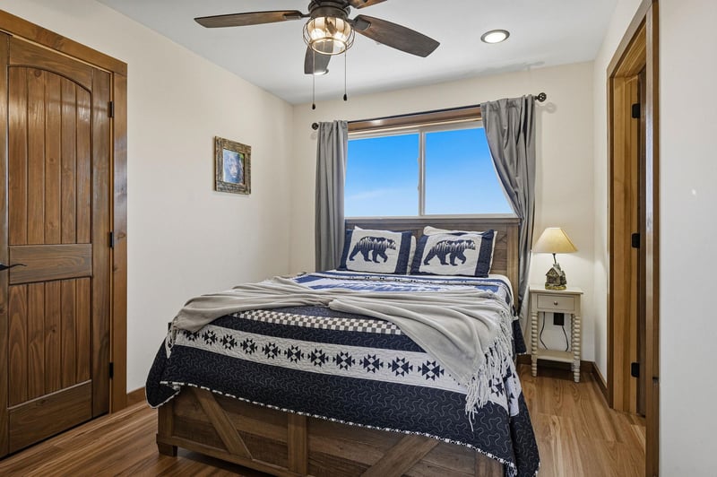 Unwind in your cozy bedroom with rustic charm and a plush bed dressed in mountaininspired linens. Soft natural light fills the space, inviting restful nights.