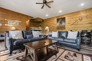 Sink into plush leather sofas surrounded by warm wood paneling, where rustic charm meets modern comfort in your cozy mountain retreat.