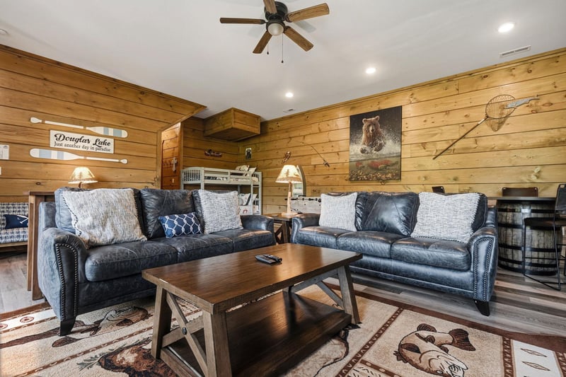 Sink into plush leather sofas surrounded by warm wood paneling, where rustic charm meets modern comfort in your cozy mountain retreat.