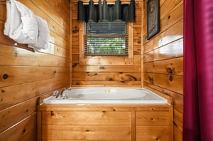 Soak away your worries in this cozy cabin tub, surrounded by warm wood and soft natural light from the window above.