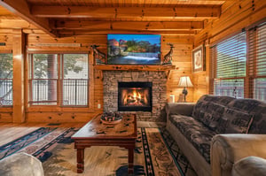 Sink into plush seating by the crackling stone fireplace. Warm wood beams, rustic charm, and natural light create your perfect mountain retreat for cozy evenings.