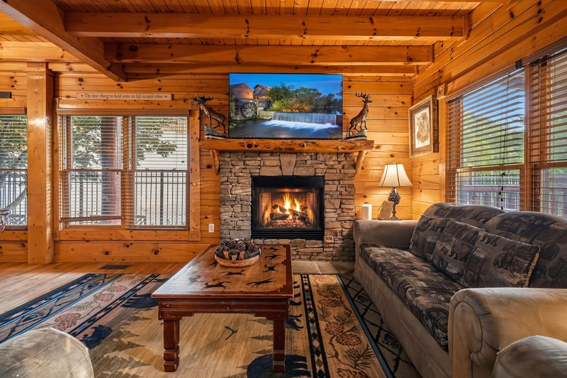 Sink into plush seating by the crackling stone fireplace. Warm wood beams, rustic charm, and natural light create your perfect mountain retreat for cozy evenings.