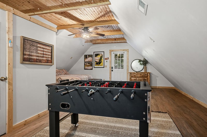 Step into your private loft game room where foosball tournaments and cozy downtime await beneath charming woodbeamed ceilings.