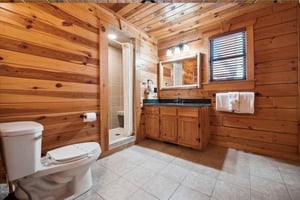 Retreat to your rustic cabin bathroom with warm wood walls and modern amenities for a perfect mountain getaway experience.