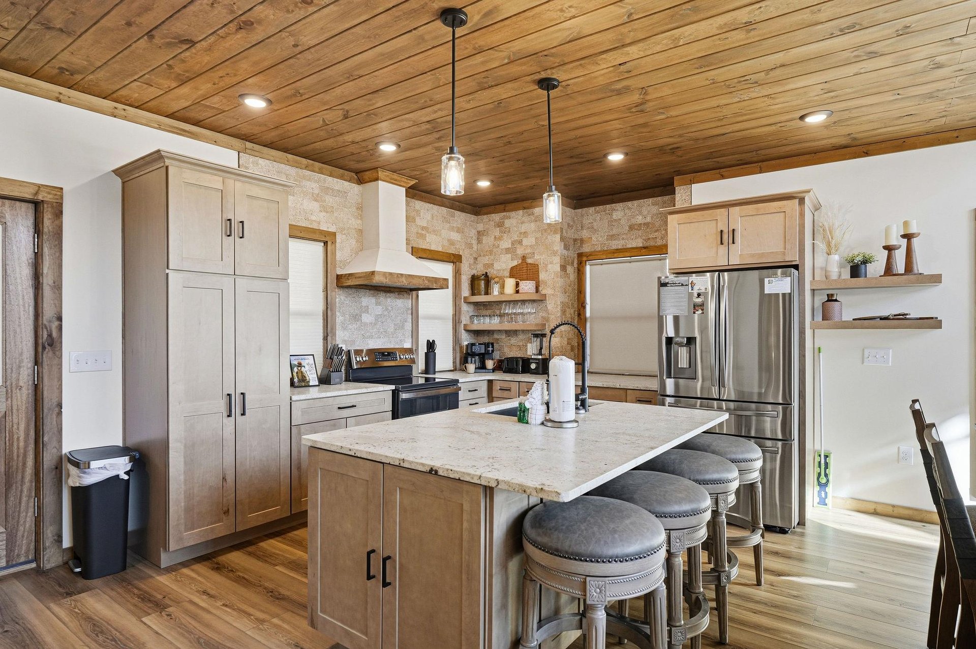 Your gourmet kitchen awaits with rustic wood ceilings, modern appliances, and a spacious island perfect for cooking memorable meals together.