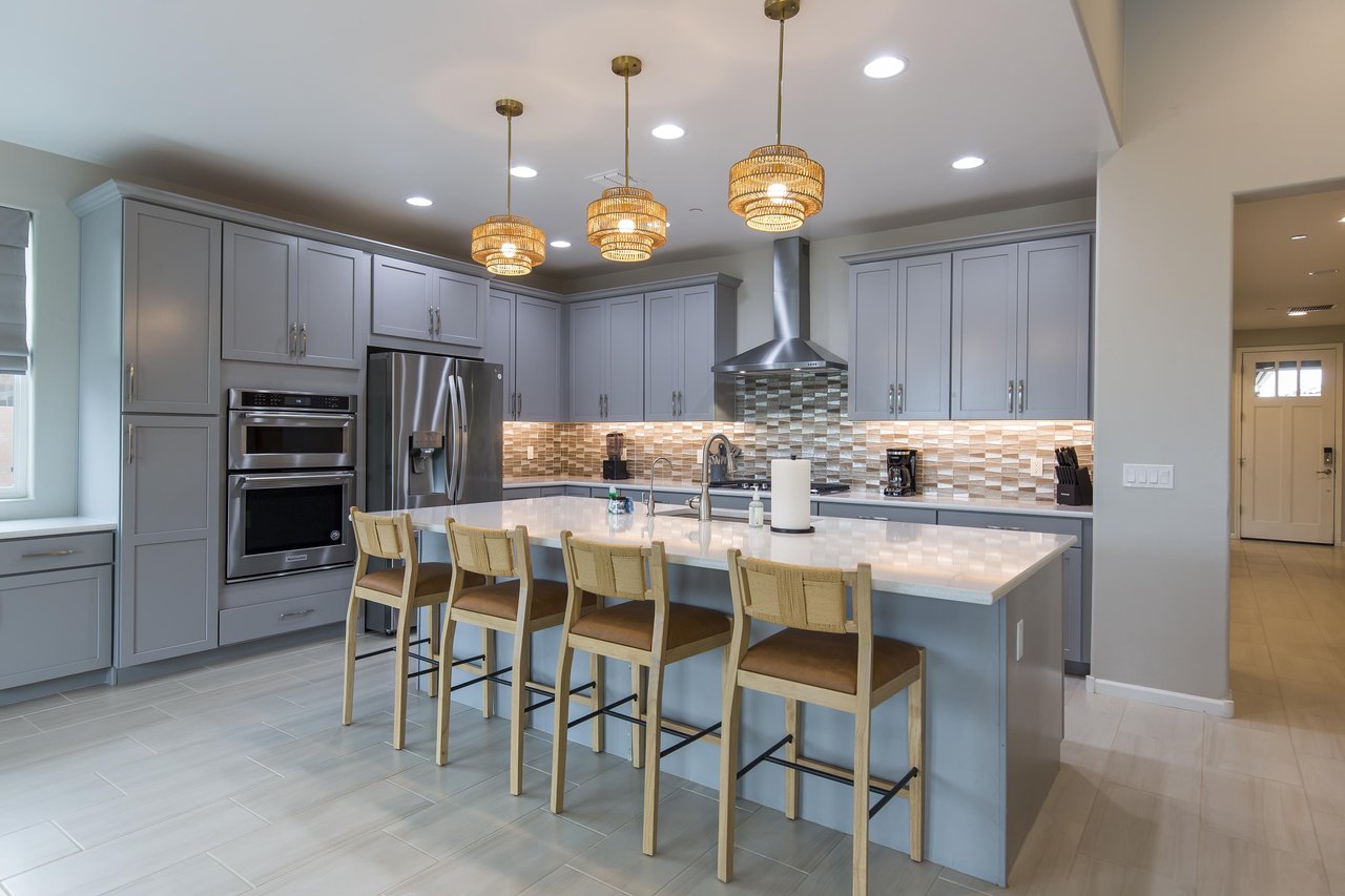Stainless steel appliances, large island with counter seating for 4 guests, and cooking essentials.