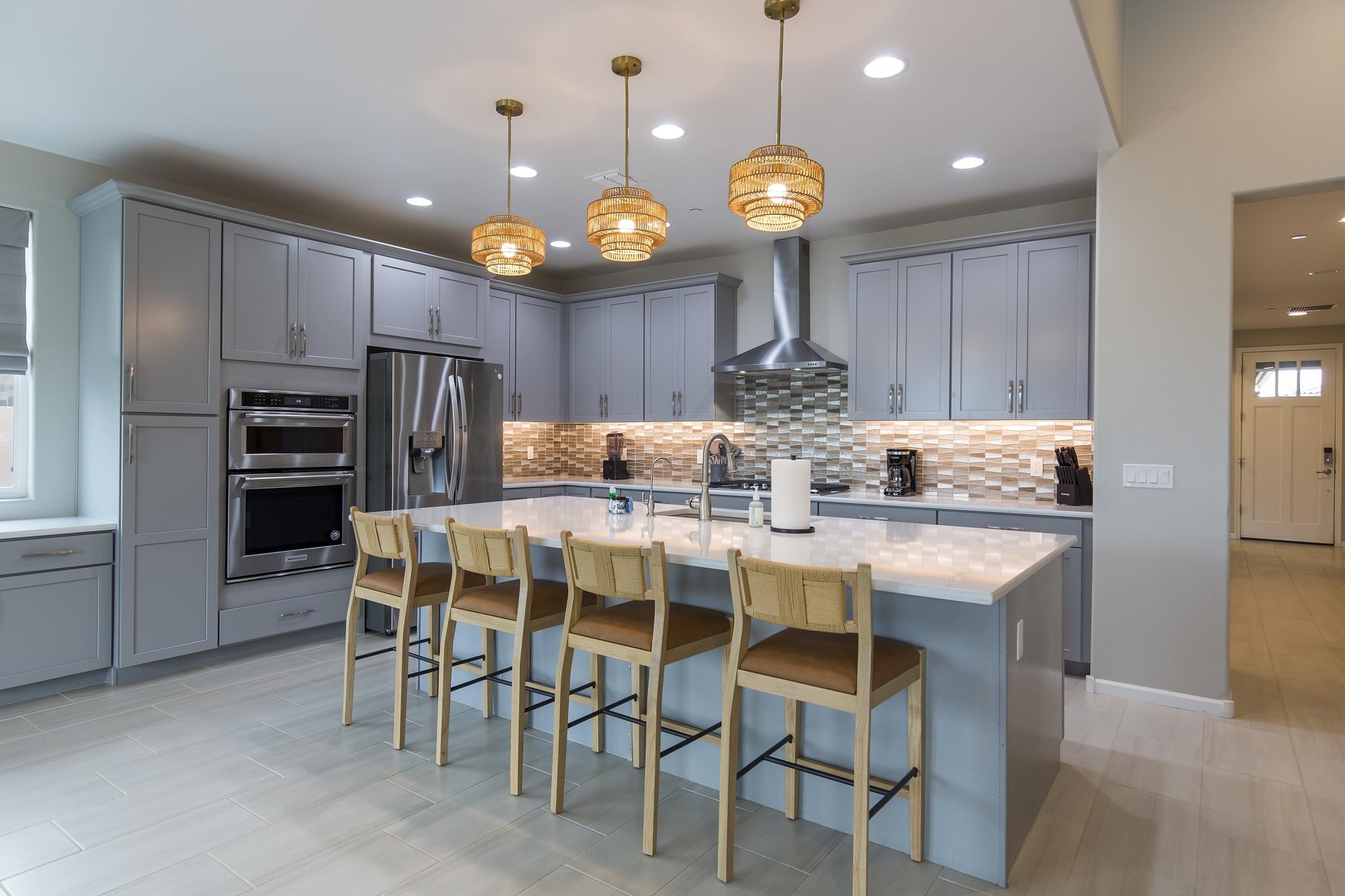 Stainless steel appliances, large island with counter seating for 4 guests, and cooking essentials.