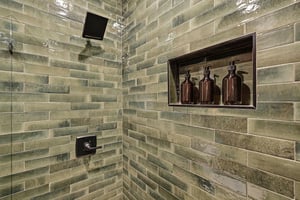 Step into your luxurious shower with elegant subway tiles and premium bath products thoughtfully arranged in a builtin niche for your comfort.