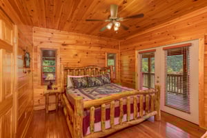 Bedroom with a log bed and deck access at Four Seasons Lodge, a 3bedroom cabin rental located in Pigeon Forge