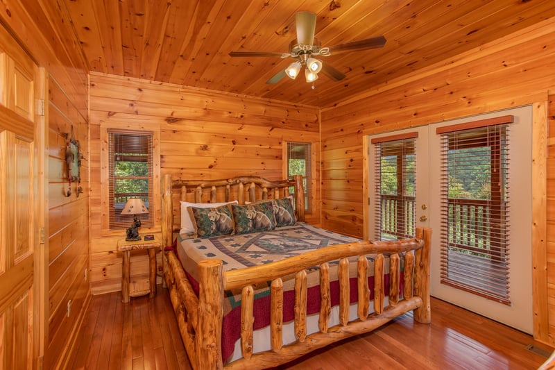 Bedroom with a log bed and deck access at Four Seasons Lodge, a 3bedroom cabin rental located in Pigeon Forge